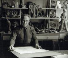 van Dijk staand achter een werk in atelier